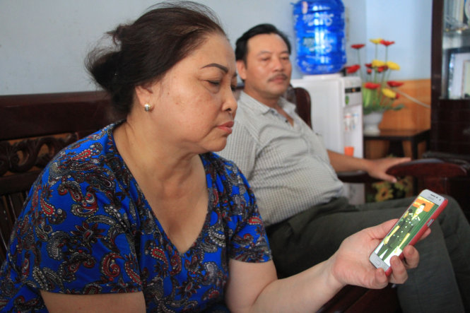 Bà Lê Thị Đào, bác ruột đại úy Lê Văn Đình đọc tin tìm kiếm cứu nạn máy bay CASA 212 - Ảnh: ĐỨC HIẾU