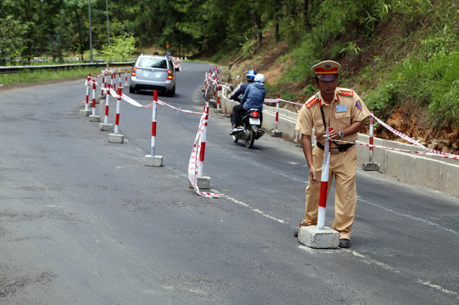 Lực lượng CSGT Công an tỉnh Lâm Đồng, nối lại dây phân làn đường tại vị trí nâng cấp đường đèo xảy ra vụ tai nạn trưa ngày 20-6 tại chân đèo Prenn - Ảnh: CHÍNH THÀNH