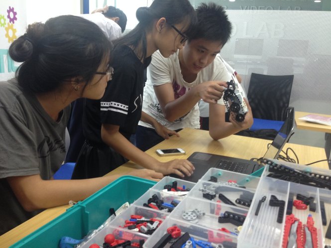 Các học viên bàn luận say mê về cách lắp ráp robot tại lớp học Robot Mindstorms - Ảnh: T.Hân