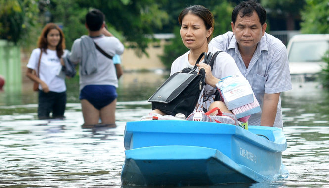 Người dân Bangkok di chuyển trong nước ngập - Ảnh: THE NATION