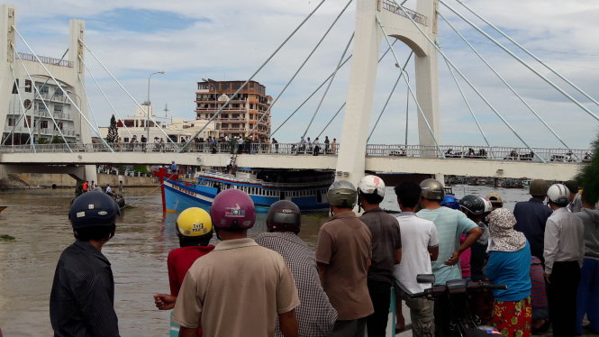 Rất đông người dân theo dõi việc cứu hộ con tàu mắc cạn dưới gầm cầu - Ảnh: NGUYỄN NAM