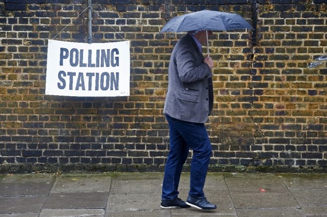 Người dân Anh ở một số nơi phải đội mưa đi bỏ phiếu - Ảnh: AFP