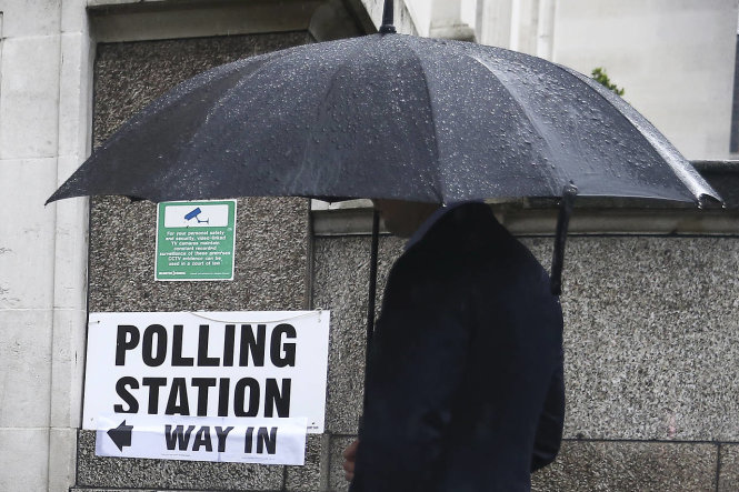 Người dân Anh đội mưa đi bỏ phiếu - Ảnh: Reuters
