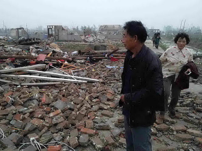 Người dân thất thần nhìn nhà cửa mình bị lốc xoáy phá hủy - Ảnh: AFP