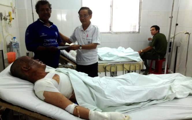 Ông Nguyễn Minh Trực đến thăm và hỗ trợ các ngư dân gặp nạn - Ảnh: HOÀNG TRUNG