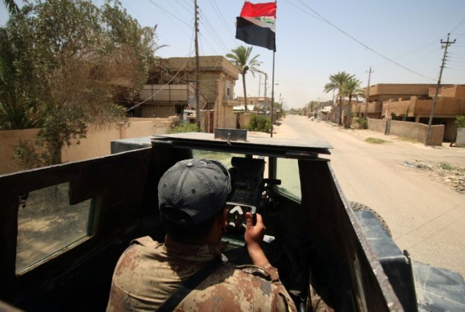 Binh sỹ Haidar Mohamed Ali, một thành viên của lực lượng chống khủng bố Iraq đang lái xe bọc thép ở thành phố Fallujah - Ảnh: AFP