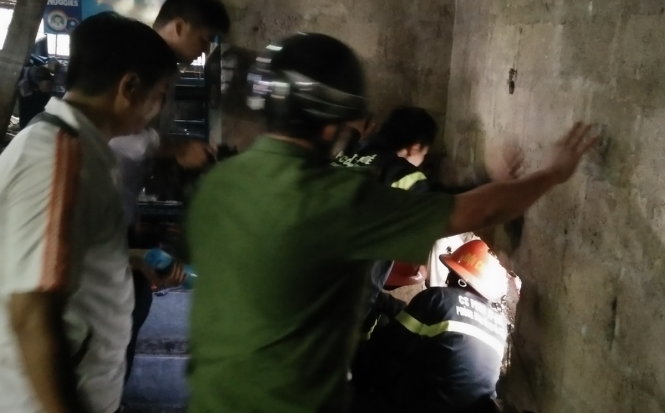 Lực lượng cứu hộ đang khoan cắt bức tường bê tông để tiếp cận, giải cứu nạn nhân - Ảnh: NGUYÊN LINH