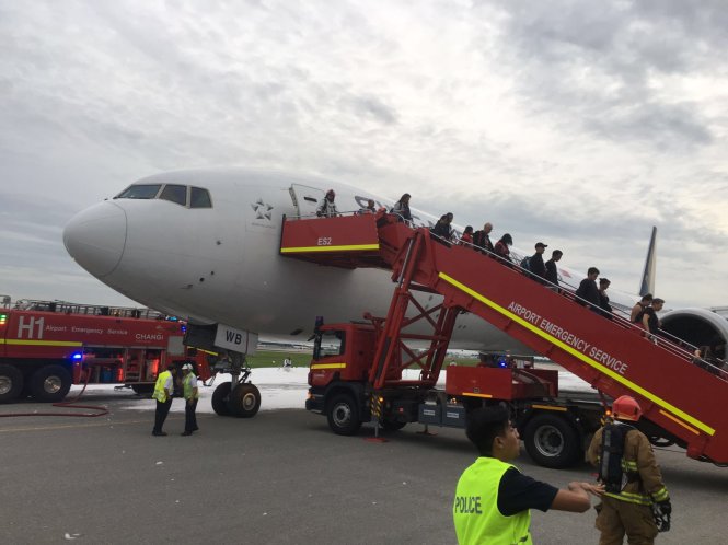 Hành khách xuống máy bay sau khi ngọn lửa được dập tắt - Ảnh: Lee Bee Yee