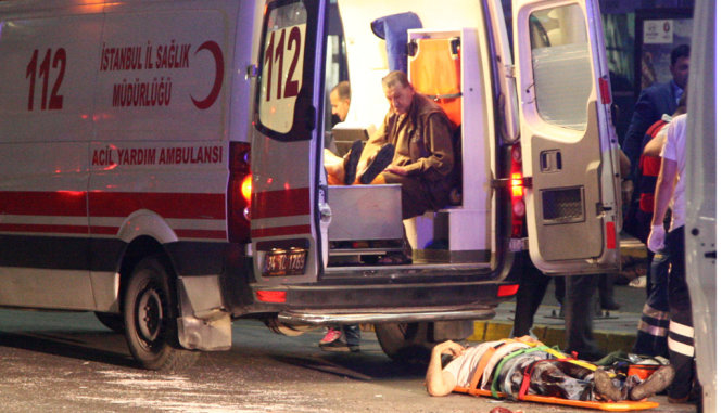 Người bị thương chuẩn bị được đưa lên xe cấp cứu - Ảnh: REUTERS