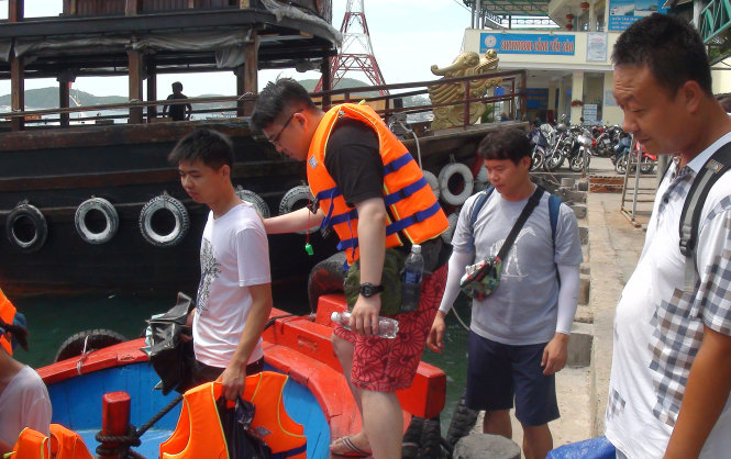 Hướng dẫn viên Trung Quốc (thứ hai từ phải sang) đưa khách tham quan vịnh Nha Trang sáng 29-6 - Ảnh: D.THANH