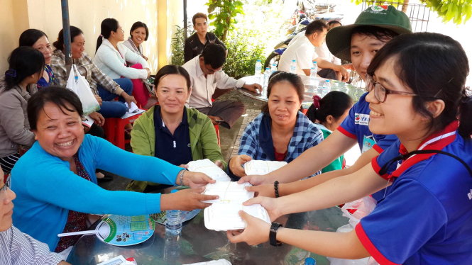 Sinh viên tình nguyện phát cơm miễn phí cho phụ huynh trước điểm thi Trường Song ngữ Lạc Hồng - Ảnh: A Lộc