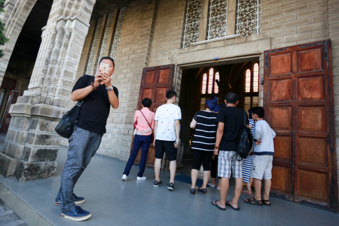 Một hướng dẫn viên người Trung Quốc đưa khách tham quan chùa Long Sơn, Nha Trang - Ảnh: T.THÀNH