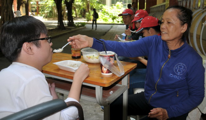 Giờ nghỉ trưa, bà Tặng đút cơm cho Chung trong khuôn viên Trường Đại học Tiền Giang - Ảnh:THANH TÚ