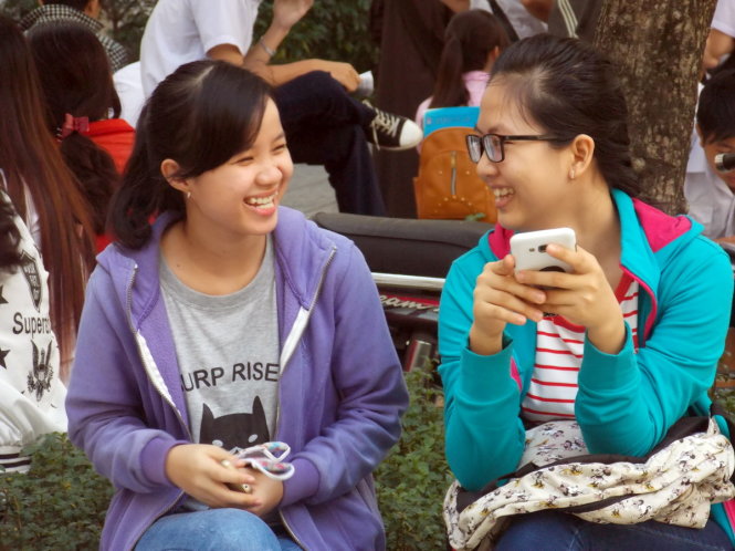 Hai thí sinh ngồi trò chuyện trước giờ thi môn Địa lí tại điểm thi Trường THPT Gia Định, TP.HCM - Ảnh: ĐÀM NA