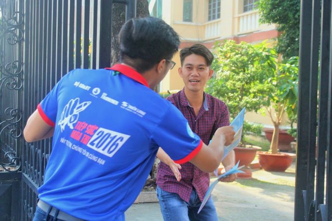 Sinh viên tiếp sức mùa thi trường ĐH Sài Gòn mua atlat đưa cho thí sinh ngay sát giờ phát đề. Ảnh: NGỌC TUYỀN