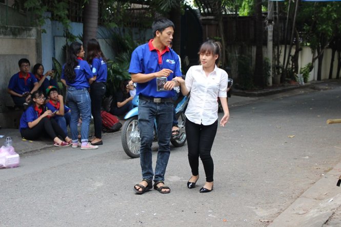 Thắng được Phương dìu vào điểm thi. Do Thắng bị khuyết tật nên đi lại rất khó khăn. - Ảnh: KIM LIÊN
