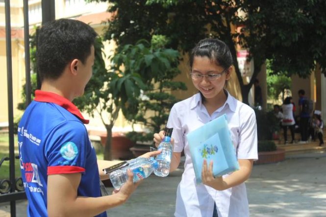 Sinh viên tình nguyện phát nước miễn phí cho thí sinh trong tiết trời nắng nóng. - Ảnh: Ngọc Tuyền