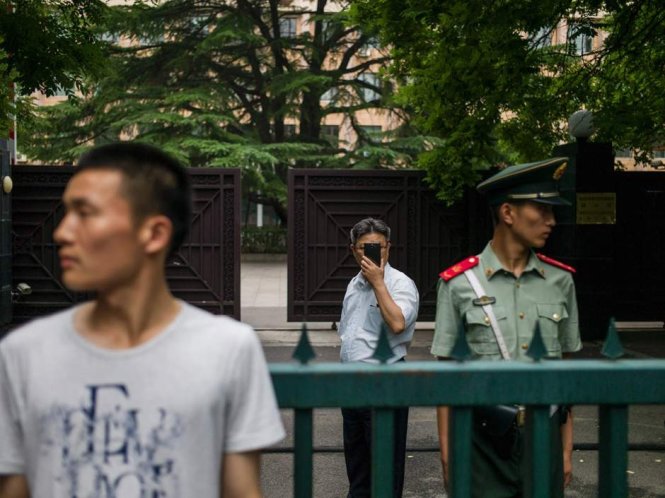 Một đại biểu CHDCND Triều Tiên (phía sau) đang chụp ảnh các nhà báo tác nghiệp tại một cuộc họp báo ở đại sứ quán CHDCND Triều Tiên tại Bắc Kinh - Ảnh: AFP