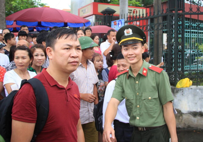 Đỗ Tùng Sơn, sinh viên lớp B2D2 HV Chính trị CAND hướng dẫn người nhà thí sinh tại điểm thi ĐH Hạ Long chờ con đứng đúng vị trí - Ảnh: ĐỨC HIẾU