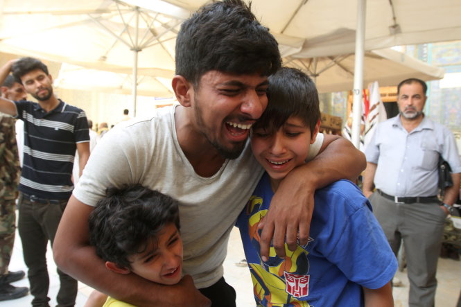 Ba cha con khóc thương người thân bị thiệt mạng trong vụ đánh bom ở thủ đô Baghdad - Ảnh: Reuters