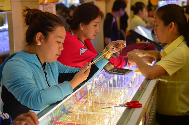 Các chuyên gia khuyến cáo người dân không nên chạy theo “sóng” vàng tăng. Trong ảnh: giao dịch tại một tiệm vàng - Ảnh: Quang Định