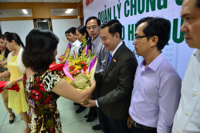 Bà Ngô Thị Thu An - ủy viên Ban biên tập báo Tuổi Trẻ tặng hoa cho các khách mời trong buổi tọa đàm Quản lý chung cư sao cho hiệu quả sáng 6-7 - Ảnh: QUANG ĐỊNH