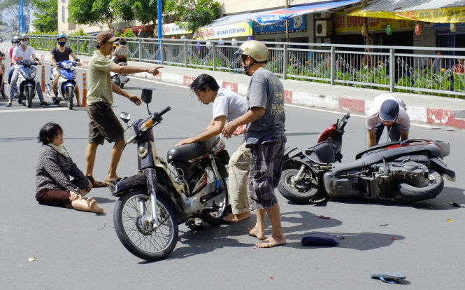 Giúp người bị tai nạn xe máy trên cầu Hoàng Hoa Thám, Q.Bình Thạnh, TP.HCM - Ảnh: CHÂU ANH