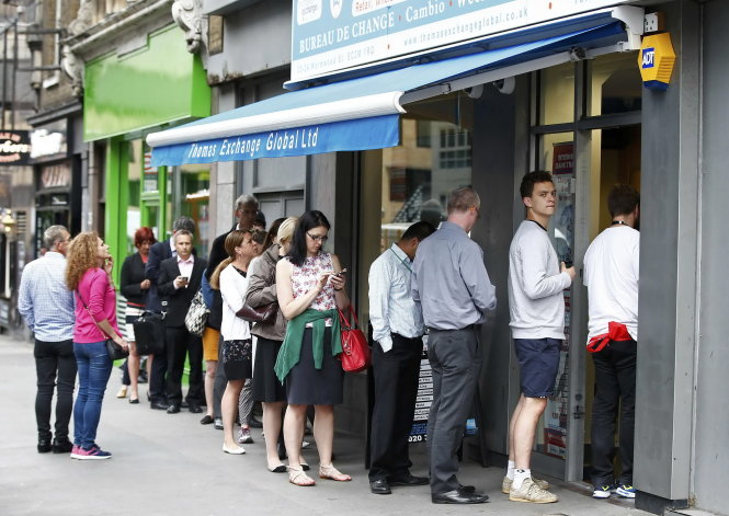 Người dân Anh xếp hàng dài trước điểm đổi ngoại tệ ở London vì đồng bảng Anh mất giá. Số đông người dân đang thiệt hại vì đồng bảng mất giá mạnh thời gian gần đây- Ảnh: Reuters