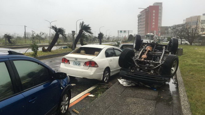 Ô tô bị lật ngửa trên đường phố Đài Loan sau khi siêu bão đổ bộ sáng 8-7 - Ảnh: James Reynolds