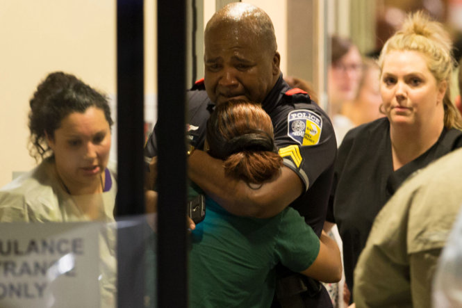 Một sĩ quan cảnh sát an ủi người thân tại bênh viện Đại học Baylor - Ảnh: AP