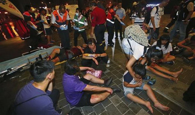 Những người bị thương đang được chăm sóc bên ngoài nhà ga sau khi xảy ra nổ - Ảnh: AP