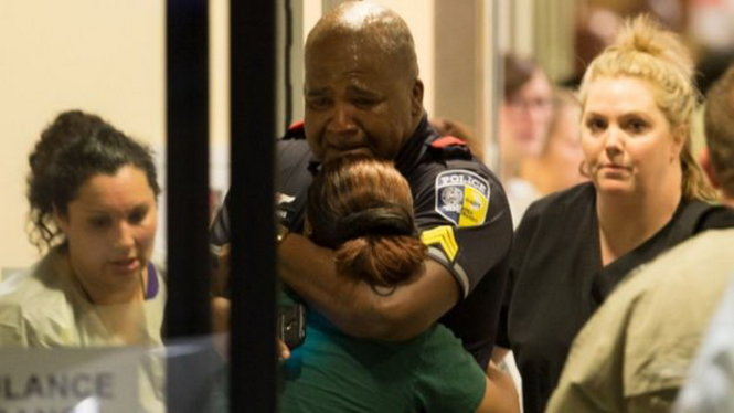 Một cảnh sát an ủi người thân tại bệnh viện ĐH Baylor - Ảnh: AP