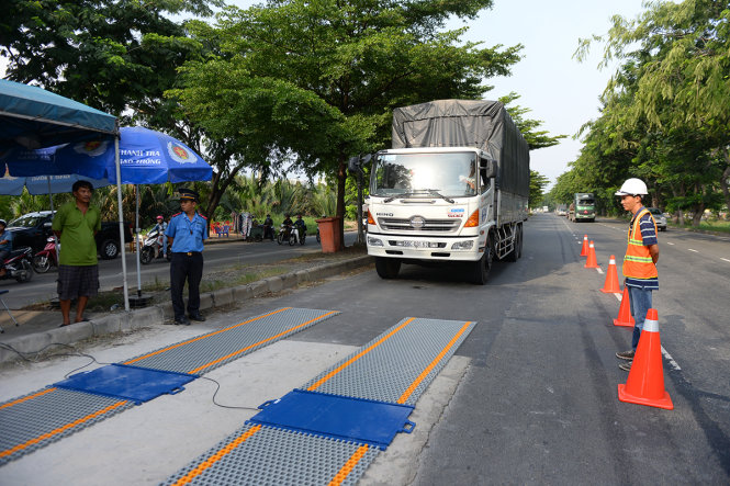 Lực lượng chức năng kiểm tra xe quá tải bằng hệ thống trạm cân tự động trên đường Nguyễn Văn Linh (đoạn qua địa bàn H.Bình Chánh, TP.HCM) - Ảnh: HỮU KHOA