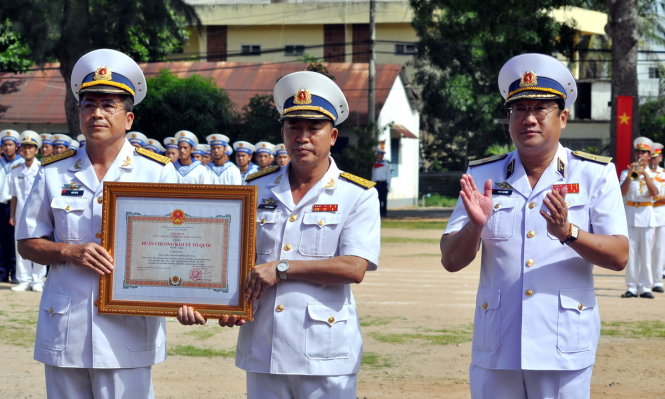 Chuẩn đô đốc Phạm Hoài Nam - Tư lệnh Quân chủng Hải quân gắn Huân chương Bảo vệ Tổ quốc hạng Nhất lên cờ Quyết thắng của Lữ đoàn 171 - Ảnh: ĐÔNG HÀ