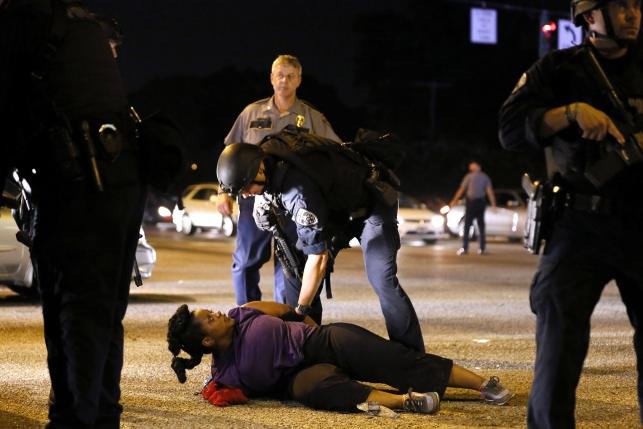 Cảnh sát bắt giữ một người phụ nữ tham gia biểu tình gần trụ sở cảnh sát Baton Rouge, Louisiana đêm ngày 9-7 - Ảnh: Reuters