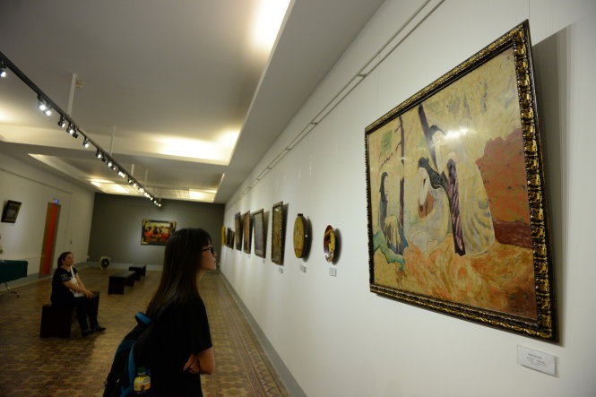 Khách xem tranh bên bức Nét duyên dáng được giới thiệu là của họa sĩ Dương Bích Liên tại triển lãm Những bức tranh trở về từ châu Âu - Ảnh: HỮU KHOA