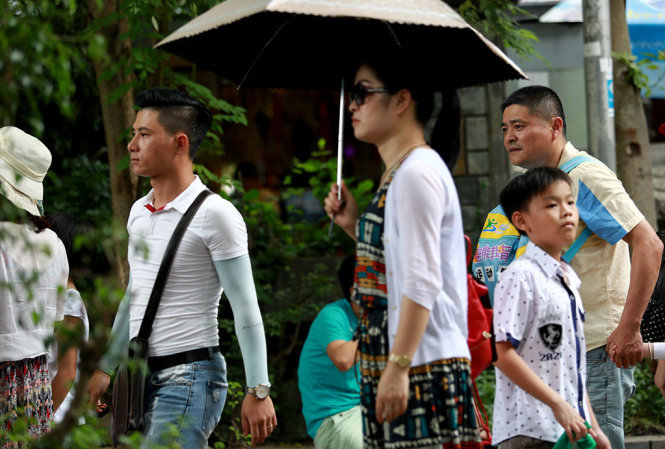 Hướng dẫn viên “chui” (bìa trái) hướng dẫn đoàn khách Trung Quốc tham quan thắng cảnh chùa Long Sơn, TP Nha Trang, Khánh Hòa vào chiều 6-7 - Ảnh: TIẾN THÀNH