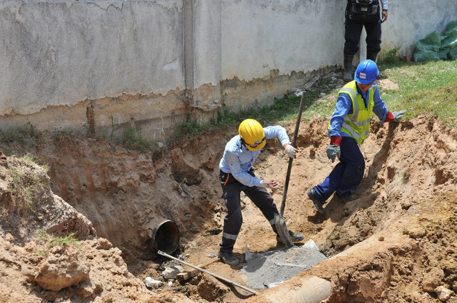 Các công nhân Formosa thực hiện việc cắt bỏ đường ống và bịt kín phần cắt - Ảnh: HỒ VĂN