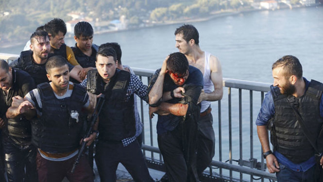 Phải rất vất vả, các nhân viên cảnh sát Thổ Nhĩ Kỳ mới bảo vệ được những binh sĩ phe đảo chính đầu hàng trên cầu Bosphorus - Ảnh: Reuters
