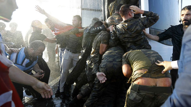 Nhóm binh sĩ phải chen chúc để tránh các đòn đánh từ đám đông - Ảnh: Reuters