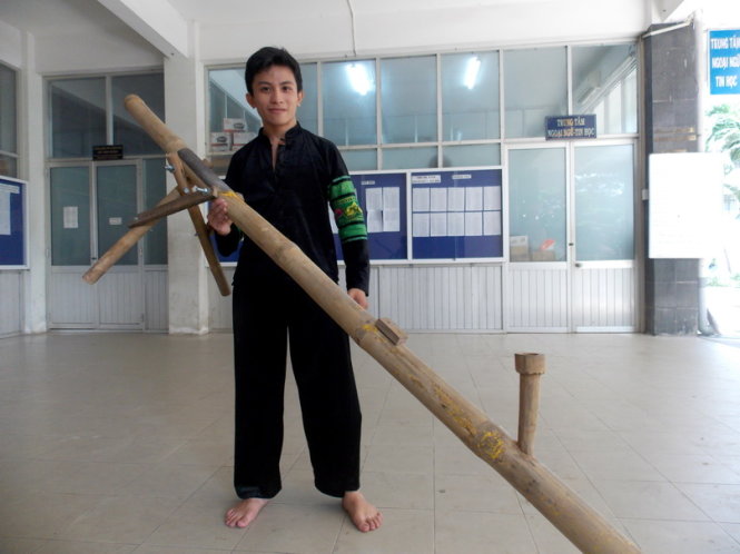 hí sinh Nguyễn Tấn Thành bên chiếc điếu cày tự chế làm đạo cụ thi múa - Ảnh: Đàm Na