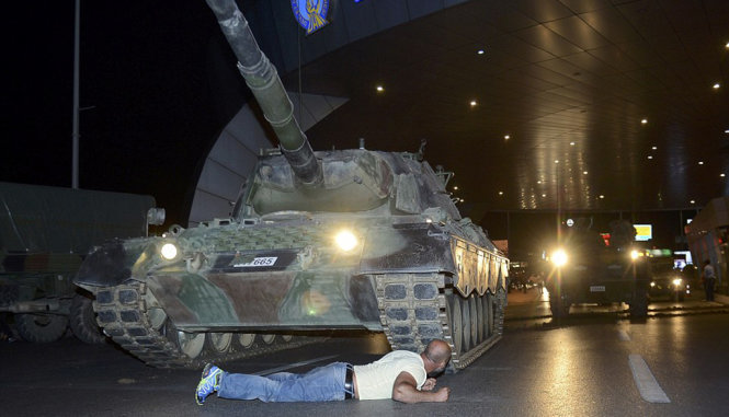 Một người ủng hộ chính phủ nằm chắn trước xe tăng để phản đối cuộc đảo chính - Ảnh: Reuters