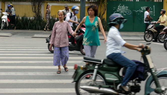 Một phụ nữ giúp người già qua đường -  một hình ảnh đẹp trên đường phố Sài Gòn (ảnh chụp trên đường Nam Kỳ Khởi Nghĩa, Q.3, TP.HCM) - Ảnh: N.C.T.