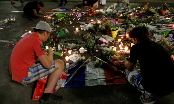Người dân Pháp đặt hoa và nến tưởng niệm các nạn nhân xấu số trên đường Promenade des Anglais, thành phố Nice, ngày 17-7 - Ảnh: Reuters
