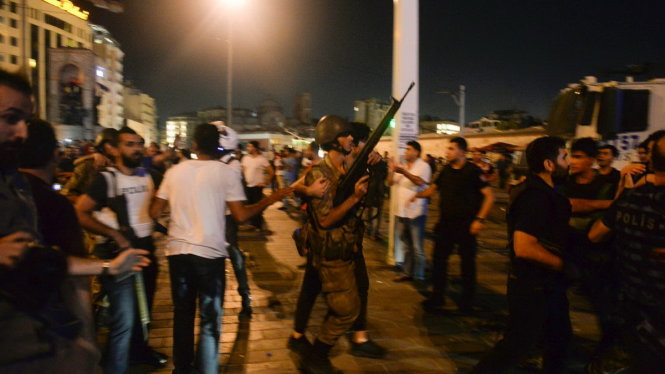 Một binh sĩ Thổ Nhĩ Kỳ bị người dân bắt giao cho cảnh sát tại quảng trường Taksim ở Istanbul sáng sớm 16-7 - Ảnh: AP
