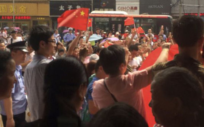 Người dân huyện Bảo Ứng, tỉnh Giang Tô, Trung Quốc, mang theo cờ và biểu ngữ biểu tình trước một cửa hàng KFC địa phương - Ảnh: AP
