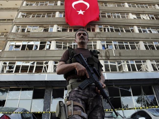 Một lính đặc nhiệm Thổ Nhĩ Kỳ đứng gác bên ngoài tòa nhà thuộc trụ sở cảnh sát đã bị phá hỏng trong vụ đảo chính vừa qua - Ảnh: AP
