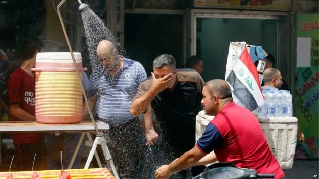 Một vòi nước bên đường giúp giải tỏa bớt cơn nóng cho người dân ở thủ đô Baghdad - Ảnh: AP