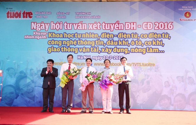 Ông Trần Anh Tuấn và ông Lê Thế Chữ tặng hoa cho các đơn vị hỗ trợ Ngày hội tư vấn, xét tuyển ĐH, CĐ 2016 - Ảnh: Nguyễn Khánh