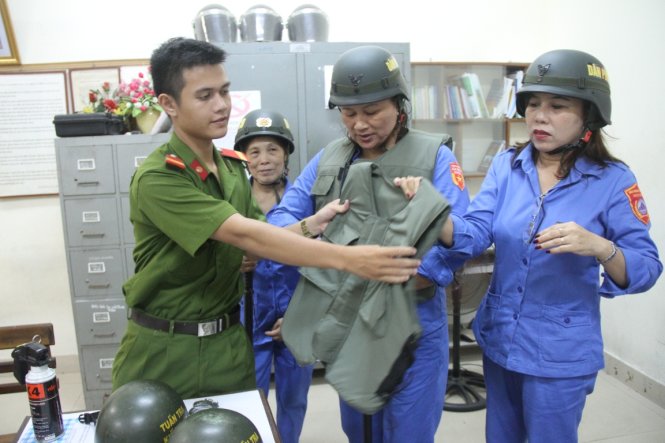 Các chị trong đội dân phòng cơ động nữ được trang bị đầy đủ trước khi làm nhiệm vụ tuần tra - Ảnh: ĐOÀN CƯỜNG
